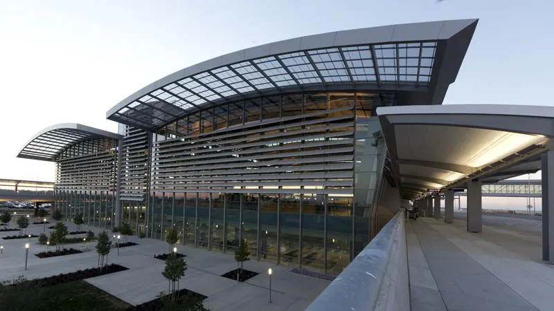 Sacramento International Airport (SMF) terminal exterior with modern glass architecture, pickup area, and landscape view.